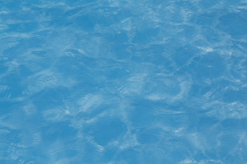 Blue pool water with sun reflections