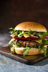  Tasty beef burger with vegetables on the table