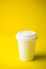 Take away coffee on yellow background