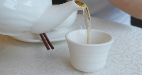 Pouring hot tea in chinese restaurant