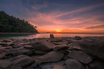 Natural close-up wallpaper of a seaside atmosphere, with a secret light, a beautiful twilight sky, with rocks of varying sizes, with forests, cool air of the wind blowing all the time. 