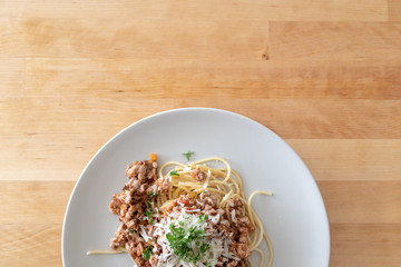 Homemade spaghetti served on wooden table.