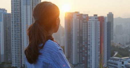 Woman look around the city with sunset light