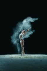 Obraz na płótnie Canvas Slim girl in lingerie in white dust cloud