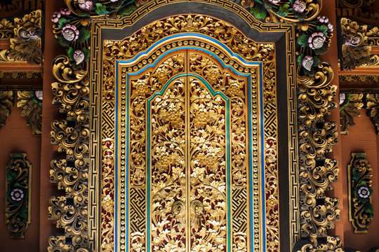 fragment of a wooden door decorated with gold in Balinese style