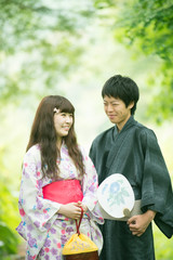 新緑の中で微笑む浴衣姿のカップル