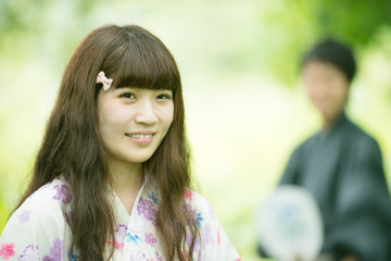 新緑の中で微笑む浴衣姿の女性