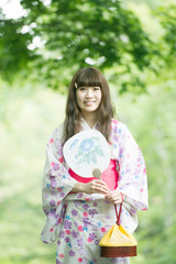うちわを持ち微笑む浴衣姿の女性