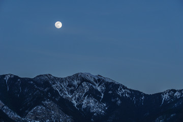 spring fool moon over mountains in british columbia canada.