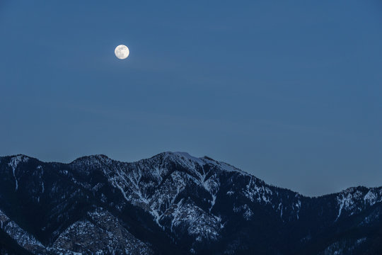 spring fool moon over mountains in british columbia canada.