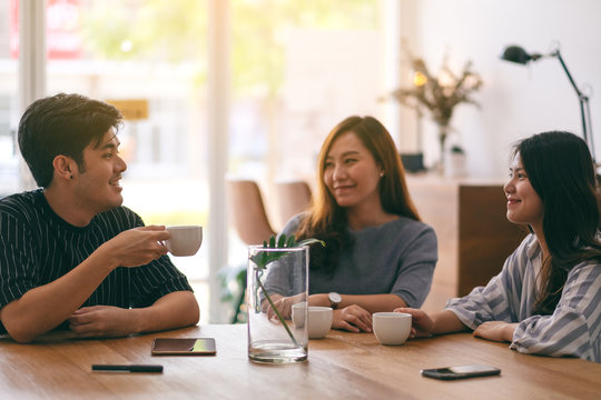 Close up image of three people enjoyed talking and drinking coffee in office