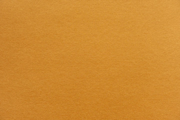 Abstract yellow glossy paper texture background or backdrop. Empty wrapping paper or shiny paperboard for decorative design element. Grainy surface for Christmas holiday or New year concept