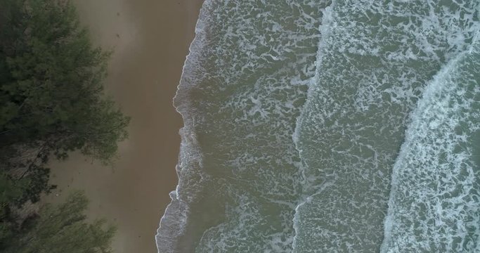 Drone raising up over the sea watching the waves roll in at Mae Pim beach Rayong Thailand