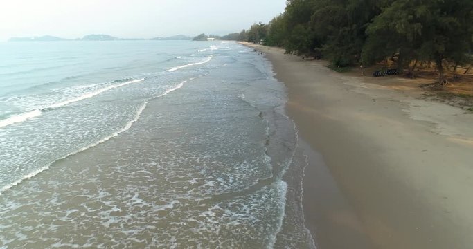 Drone flying over the beach watching the waves roll in at Mae Pim beach Rayong Thailand