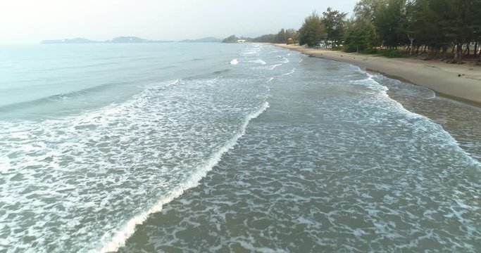 Drone flying over the sea above the waves roll in at Mae Pim beach Rayong Thailand