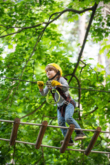 Naklejka na ściany i meble Go Ape Adventure. Climber child on training. Child climbing on high rope park. Children fun. Cargo net climbing and hanging log. Active children. Roping park