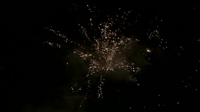 Fireworks exploding in the night sky while rainy stock footage