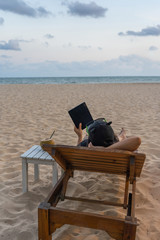 Vertical photo of young girl use tablet on the beach