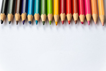 Farbenfrohe Reihe Buntstifte wartet auf den Schulanfang eines Schülers und dessen bunte Bilder auf...