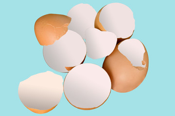 Broken eggs on blue pastel background