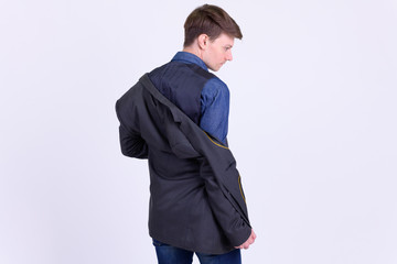 Rear view of young handsome businessman in suit undressing jacket