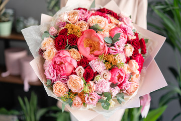 Large Beautiful bouquet of mixed flowers in woman hand. Floral shop concept . Beautiful fresh cut bouquet. Flowers delivery