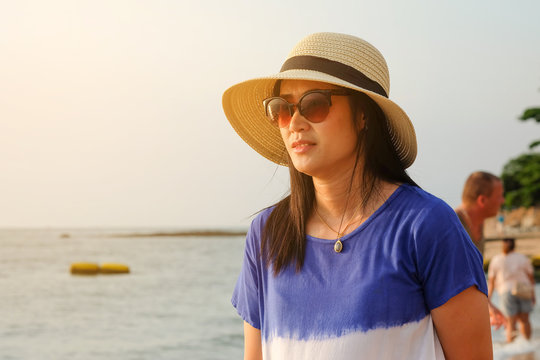 Asian Women Wearing Hats And Sunglasses At The Seaside On A Summer Vacation