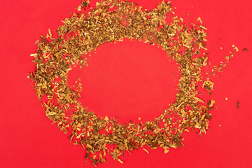 Frame of dry tobacco on red background. Copy space