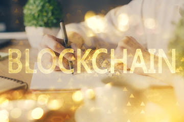 Cryptocurrency hologram, bitcoin, ico theme over hands taking notes background. Concept of...