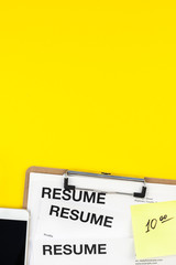 Job application flat lay on yellow background