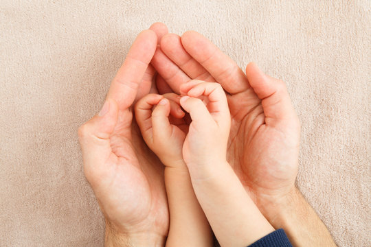 adult and child hands holding red heart