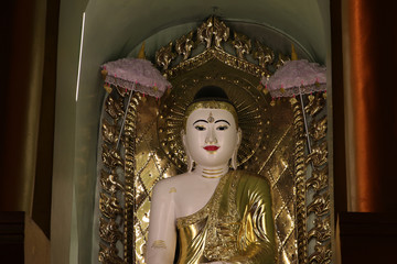 Night shot of stucco buddha statue decorated in golden be enshrined inside the arch at Shwedagon...