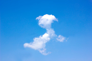 The cloud is shaped as a dog on blue sky background