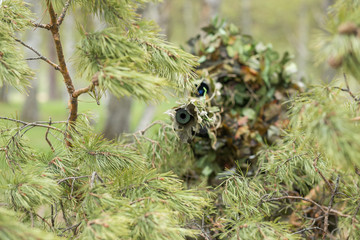 Camouflaged sniper in the forest