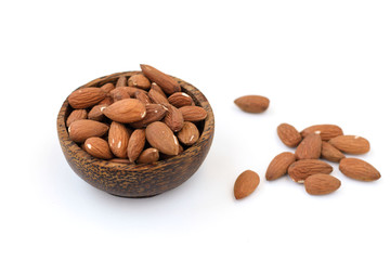 Almond nuts in a brown bowl on a white background