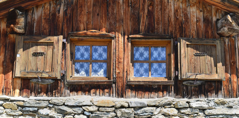 close on two little window on a facade of a mountain chalet