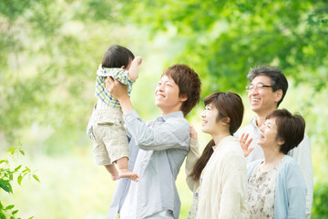 新緑の中で微笑む3世代家族
