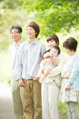 新緑の中で微笑む3世代家族