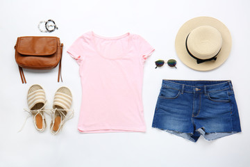 Stylish female clothes with accessories on white background