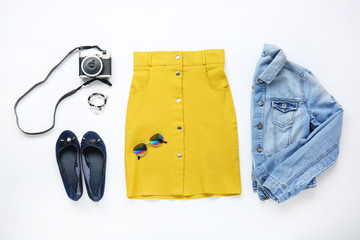 Stylish female clothes with accessories and photo camera on white background. Travel concept