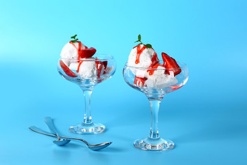 Glass bowls with tasty ice cream on color background