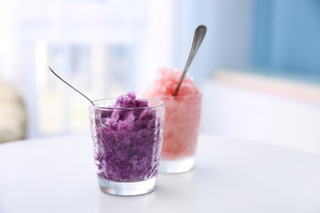 Glasses with tasty shaved ice on white table