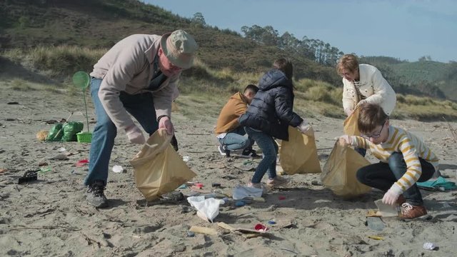 Group of volunteers picking up trash on the beach
