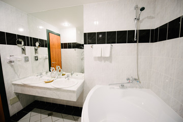 Bathroom in the apartment with white marble tiles with bath, toilet and wash basin
