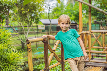 Obraz premium The boy at the bamboo playground. Eco-friendly playground