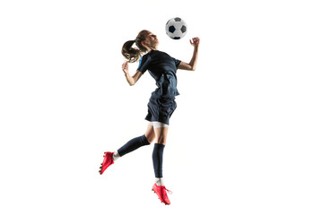 Young female football or soccer player with long hair in sportwear and boots kicking ball for the...