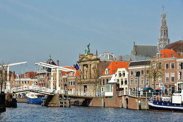 The Spaarne riverside, with Teylers Museum, Gravestenenbrug bridge and the clock tower of St Bavokerk Church in the background, Haarlem, Netherlands