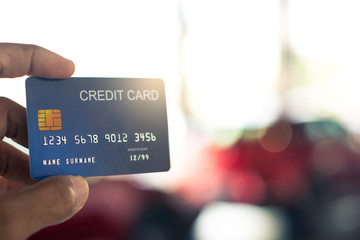 man holding credit card for car blurred bokeh background e-shopping