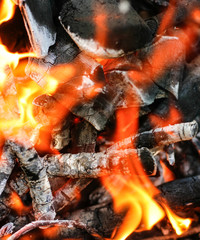 close up of an fire burning inside a charcoal grill