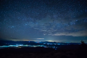 Starry sky over the city in the fog